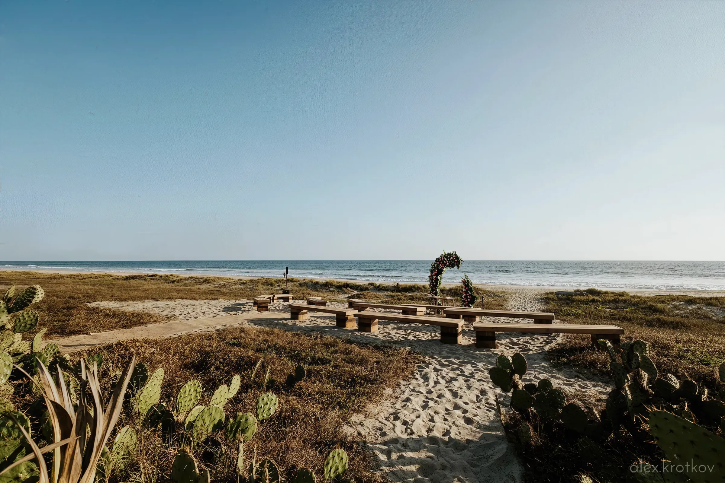 Wedding bench with flower arch in front of the sea